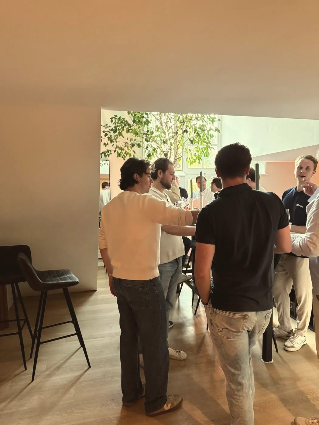 Een groep collega's in gesprek met een glas wijn